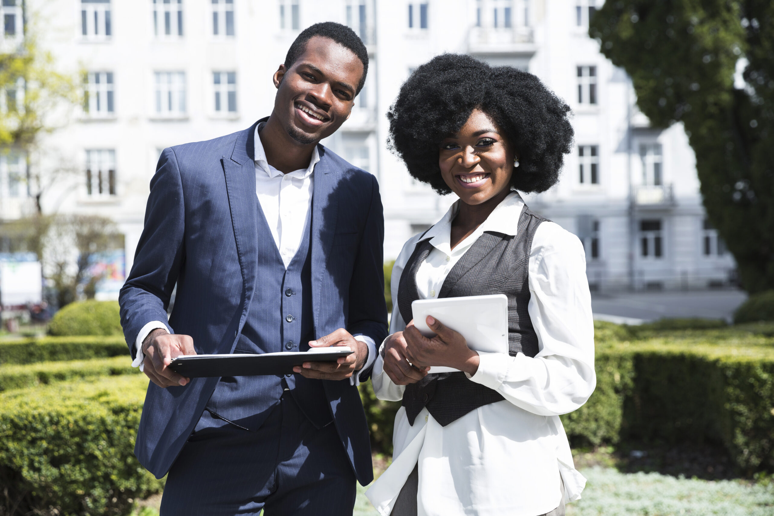 portrait african young businessman businesswoman holding clipboard digital tablet looking camera