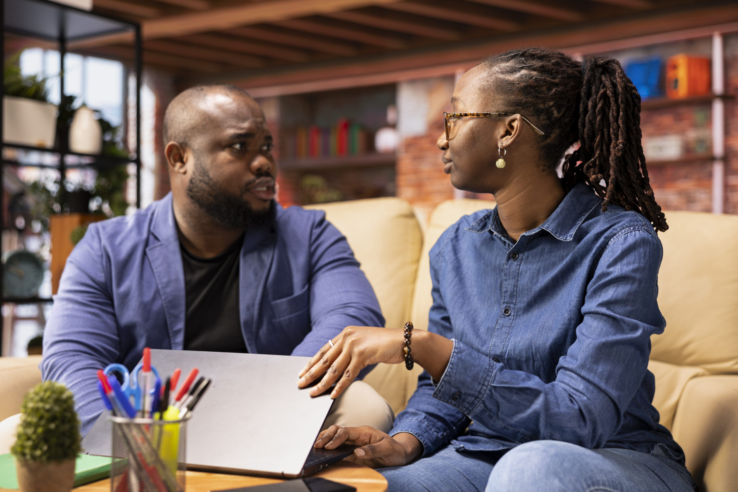 young couple in their living room browsing websites on a laptop together